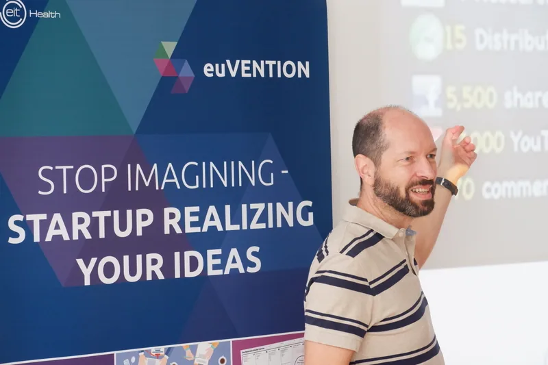 Georg Fischer lehrt vor einer Projektion und einem euVENTION-Banner.
